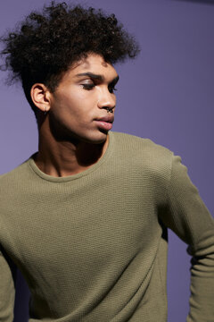 Close-up portrait of youth afroamerican male with curly black hair posing on isolate purple background