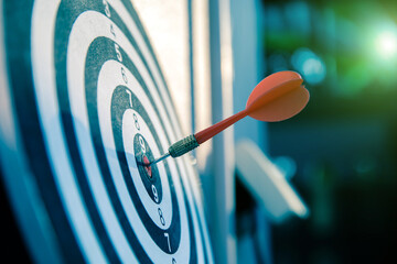 Bullseye or Bulls eye target or dartboard has dart arrow throw hitting the center of a shooting for...