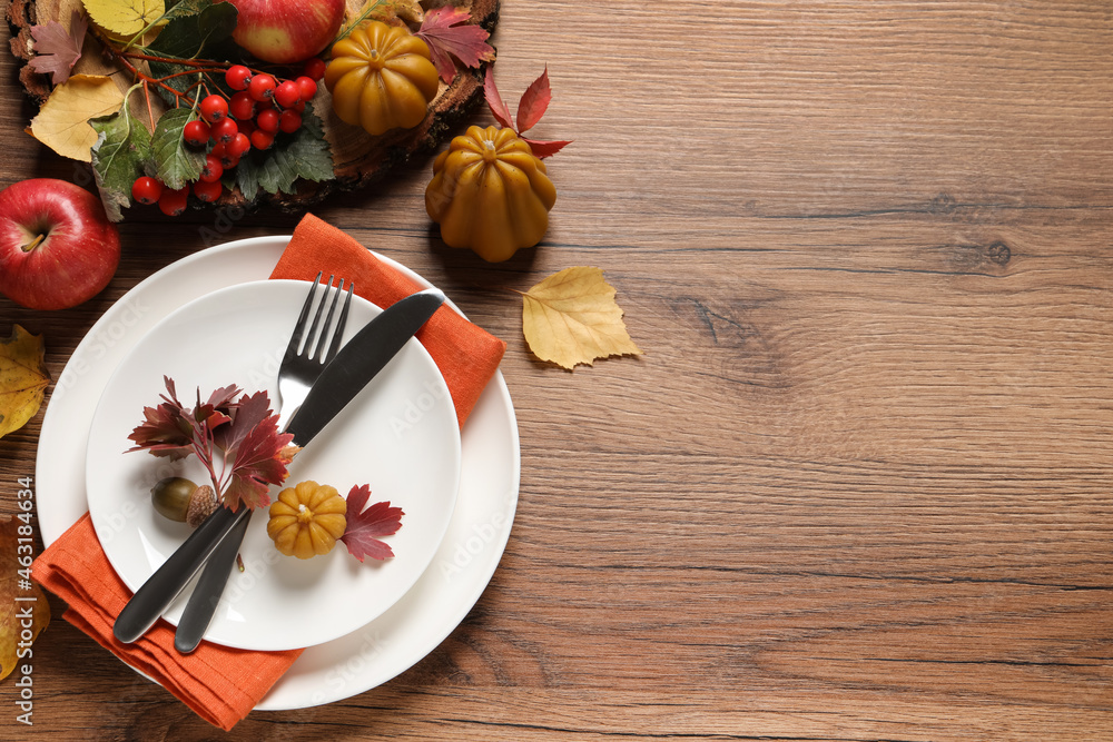 Sticker Festive table setting with autumn decor on wooden background, flat lay. Space for text