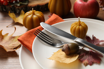 Festive table setting with autumn decor on wooden desk, closeup