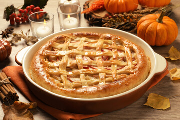 Delicious homemade apple pie and autumn leaves on wooden table. Thanksgiving Day celebration