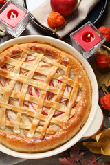 Delicious homemade apple pie and autumn decor on wooden table, flat lay. Thanksgiving Day celebration