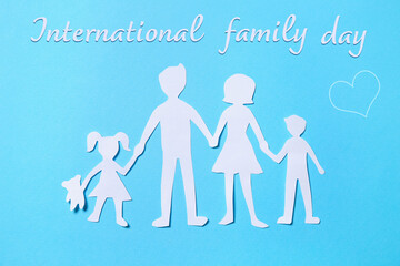 Paper figures of parents and their children on light blue background, top view. Happy Family Day