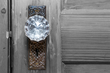 Vintage Crystal Doorknob on gray weathered wooden door. Close up photo of a beautiful antique...