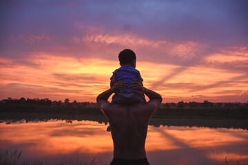 silhouette of father and son at sunset happy life