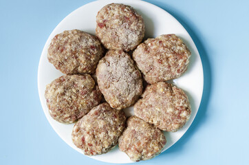 Homemade meat cutlets in close-up on a white plate. Homemade meat cuisine on a colored background