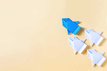 The concept of competition and rivalry. A blue paper car competes with nondescript white cars on a colored background