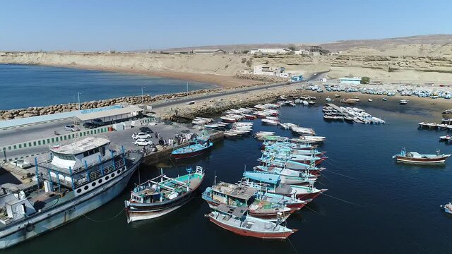 Beris, iran - ‎December ‎4, ‎2019: Aerial pan shot of fishing boats in port of Beris of chabahar, The fish boats moored in the harbor with docked yachts, Iran