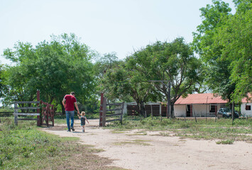 Fototapeta premium Father and child walking to the room with their backs turned