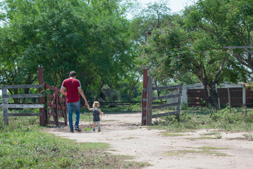 Fototapeta premium Father and child walking to the room with their backs turned