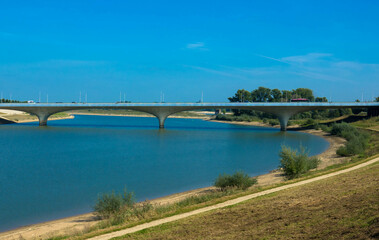 The new Lentloper bridge across the new channel of the river Waal with in the background the city of Nijmegen seen from Oosterhoutsedijk. Gelderland Province, Netherlands