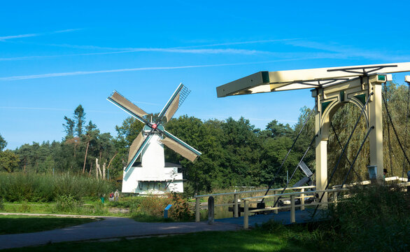 Historic dutch village with windmill and drawbridge in front of a lake. Arnhem in the Netherlands. Tourism and vacations concept.