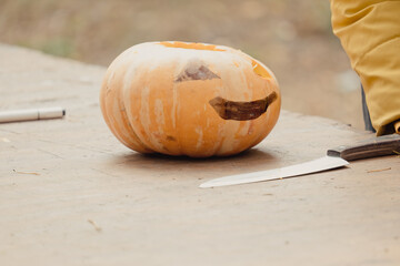 Preparation for Halloween: girl cutting pumpkin. Closeup. Holiday decoration concept. Woman...