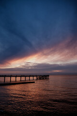 Fototapeta na wymiar lilac sunset over the sea, promenade, pier