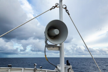 The loudspeaker is attached to the mast of a ship at sea.