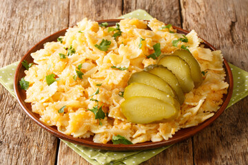 Popular European Granadir march pasta with boiled potatoes and onions served with pickles close-up...