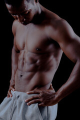 Fototapeta na wymiar Muscled male model showing his muscles. on a black background