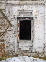 a black ominous window in the wall of a stone building