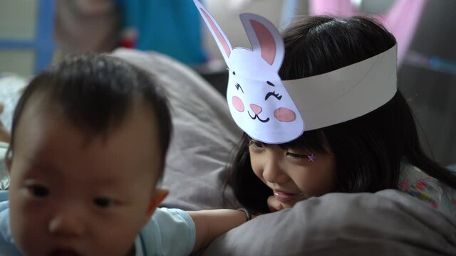 Sister wear rabbit hat and play with her little baby brother