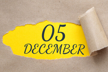 december 05. 05th day of the month, calendar date.Hole in paper with edges torn off. Yellow background is visible through ragged hole.Winter month, day of the year concept