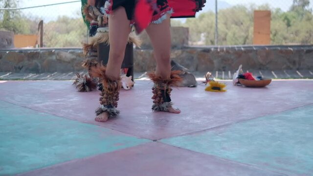 Dancer performing dance of pre-Hispanic culture with bright sky as background