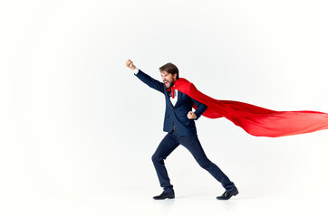 man in suit with red cloak hold hand above head superhero light background