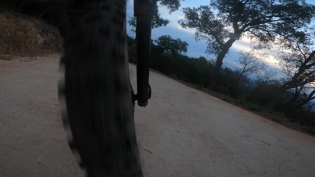 Front mountain bike wheel perspective riding on a rock trail downhill