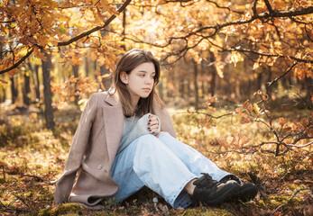 Young teenager girl in the autumn forest