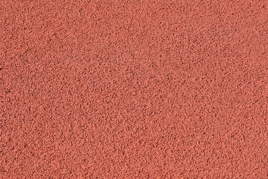 Texture of a rubber crumb for stadium. Rubber asphalt. Resilient coating for sports and athletics fields, jogging, running track and cycling paths