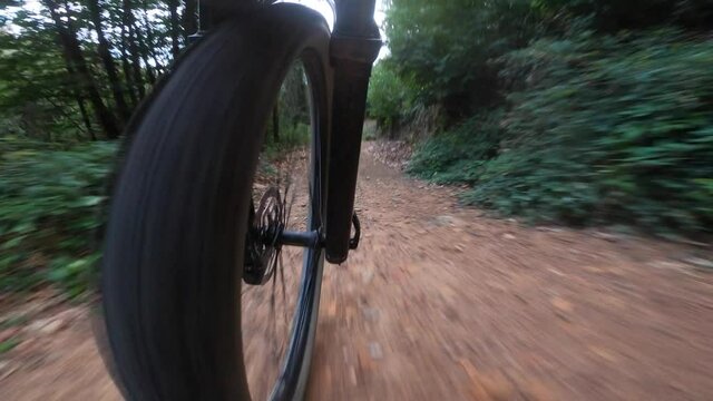 Front mountain bike wheel perspective riding on a rock trail downhill