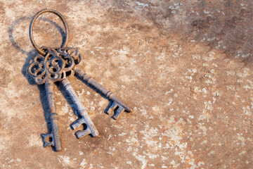 Three old antique metal keys on a rusty metall background. Middle Ages.
