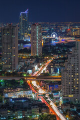 Fototapeta premium Aerial view night time lapse of landmark financial district and business center with skyscraper over Chao Phraya River at Bangkok, Thailand.