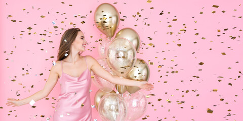 Happy caucasian girl celebrates New Year or Happy Birthday party with air balloons throwing confetti