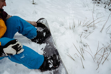 Snowboarder sitting alone in the snow, mountain outdoor, winter sport activity.