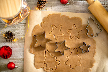Raw dough for cookies, cookie cutters, festive decoration on wooden table. Christmas sweet food