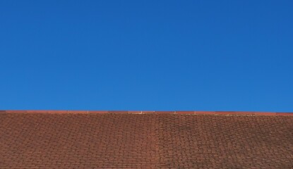 Deep blue sky and tiled roof background with space for copy
