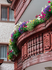 Traditional alpine wooden balconies decorated with flowers, especially typical of German Switzerland and Tyrol. Samnaun, Switzerland, a duty free village.