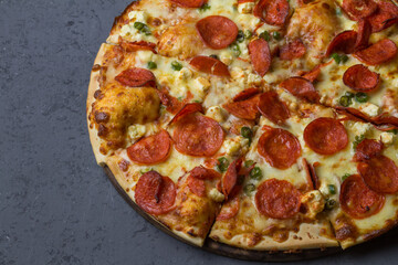 Pepperoni pizza sliced and isolated on grey with space for text