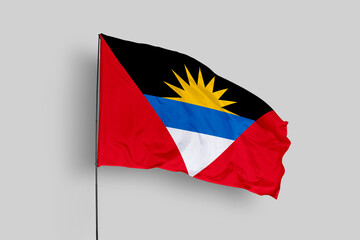Antigua and Barbuda flag isolated on the blue sky background. close up waving flag of Antigua and Barbuda. flag symbols of Antigua and Barbuda. Concept of Antigua and Barbuda.