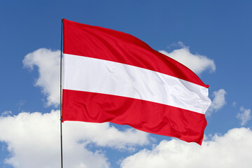 Fototapeta na wymiar Austria flag isolated on the blue sky background. close up waving flag of Austria. flag symbols of Austria. Concept of Austria.