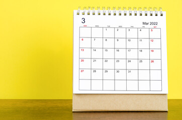 March 2022 desk calendar with yellow background.