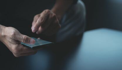 Close up, man hand using mobile phone chatting via social media apps with screen light
