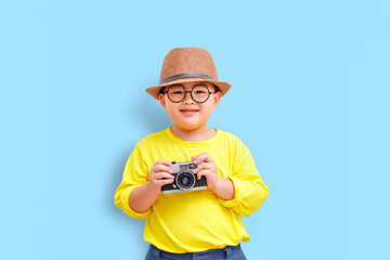 Obraz premium Cute boy having fun with his camera and going on a trip as a tourist.