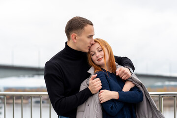 couple in love, guy puts his jacket on girl's shoulders in cold weather