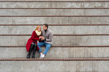 couple in love, a guy and a girl are sitting together in an empty stands