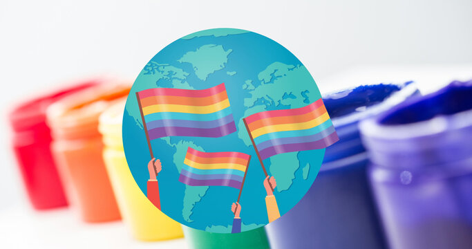 Image of rainbow flags over globe with paints in background - Powered by Adobe