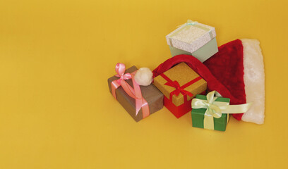 Santa Claus hat with Christmas presents on a yellow background.
