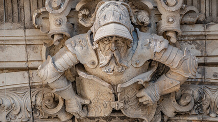 Ancient big statute of scary, fearful and heavy armed gatekeeper, medieval warrior with weapon in historical downtown of Dresden, Germany, details, closeup. Authentic European old architecture.