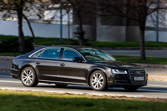 Moscow; Russia - October 14; 2021:black Audi A8 is driving fast on the street on a warm autumn day against the backdrop of a  park