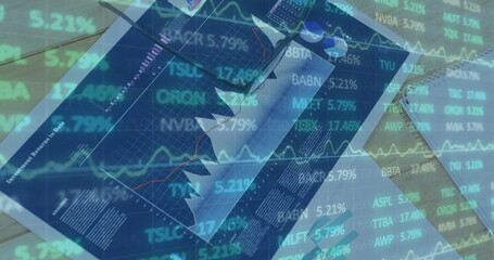 Image of financial data processing over person writing in office